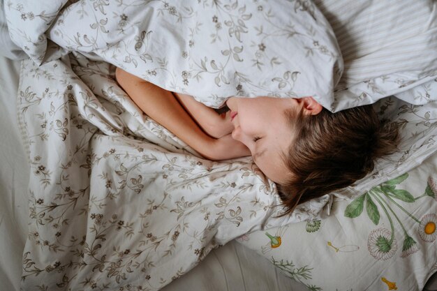 Foto vista de ángulo alto de un niño durmiendo en la cama