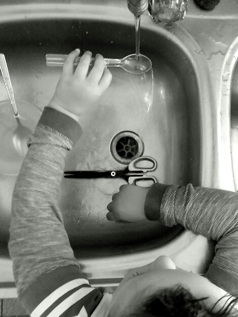 Vista de ángulo alto de un niño en el fregadero de la cocina