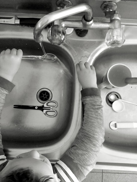 Vista de ángulo alto de un niño en el fregadero de la cocina