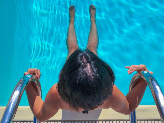 Foto vista de ángulo alto de un niño nadando en la piscina