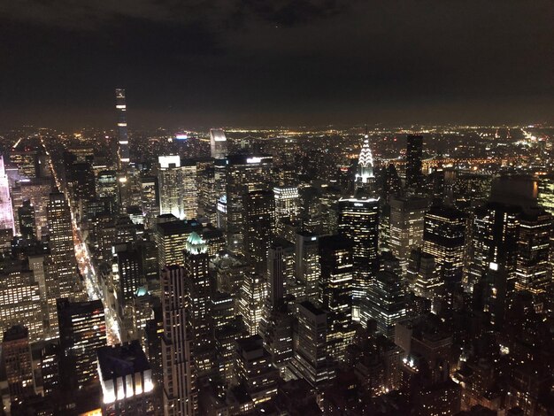 Foto vista de ángulo alto del paisaje urbano iluminado contra el cielo nocturno