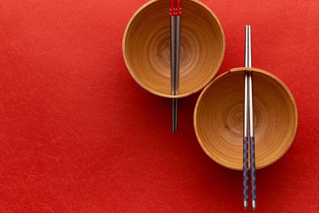 Foto vista de ángulo alto de palillos y cuencos en la mesa roja