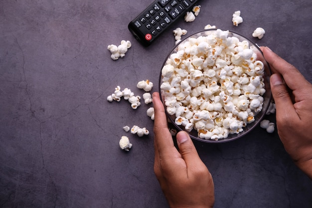 Vista de ángulo alto de palomitas de maíz y control remoto de TV en la mesa