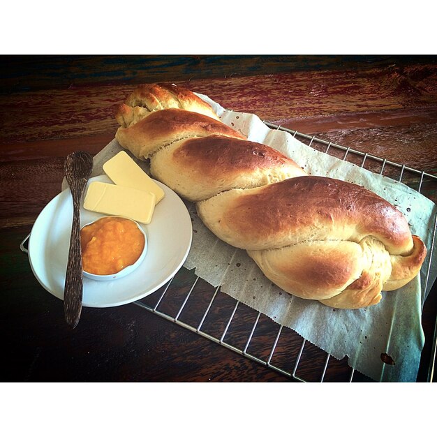 Foto vista de ángulo alto de pan trenzado con mermelada y queso en la mesa