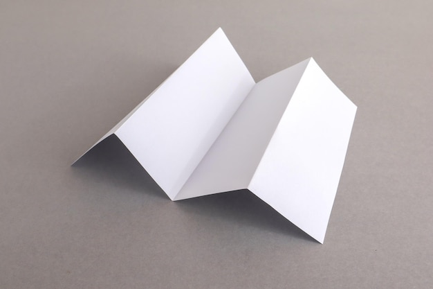 Vista de ángulo alto de papel plegado en blanco en la mesa