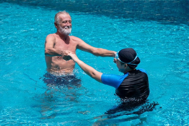 Vista de ángulo alto de una pareja tomándose de la mano mientras bailan en la piscina