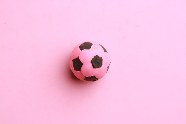 Foto vista de ángulo alto de una pelota de fútbol sobre un fondo rosa