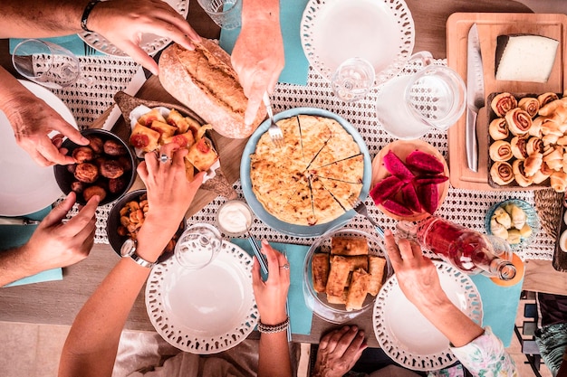 Vista de ángulo alto de personas con comida en la mesa de comedor