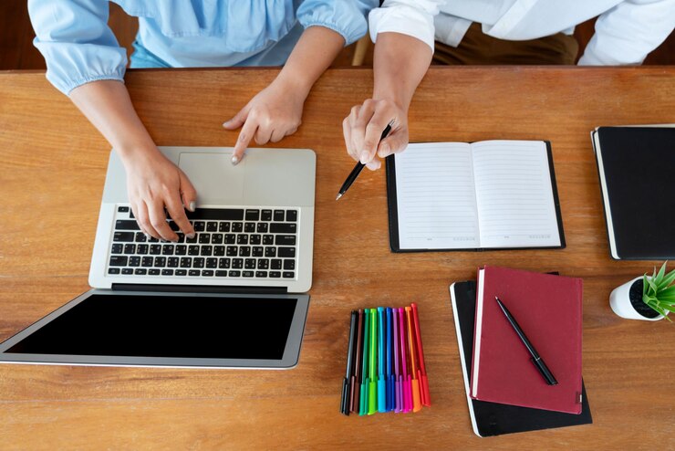 Foto vista de ángulo alto de personas que usan computadora portátil en la mesa