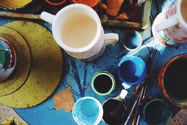 Foto vista de ángulo alto de pinceles y tazas en la mesa