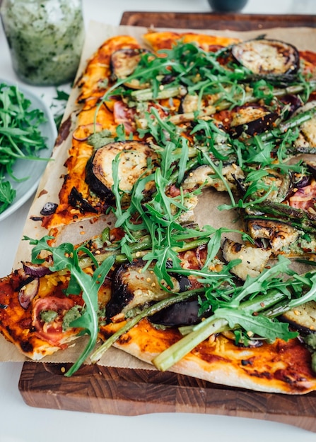 Foto vista de ángulo alto de la pizza en la tabla de cortar