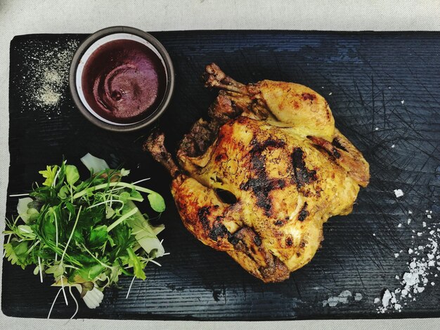 Foto vista de ángulo alto de pollo asado en la tabla de cortar