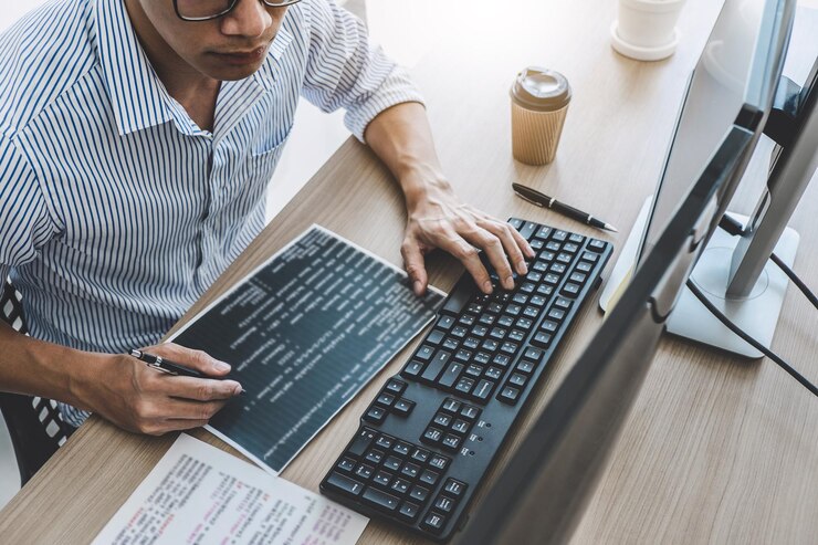 Foto vista de ángulo alto de un programador de computadoras trabajando en un escritorio en la oficina