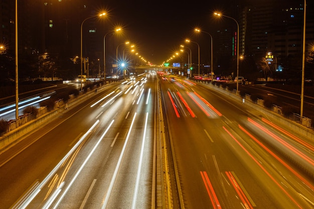 Vista de ángulo alto de los rastros de luz en la autopista de varios carriles por la noche