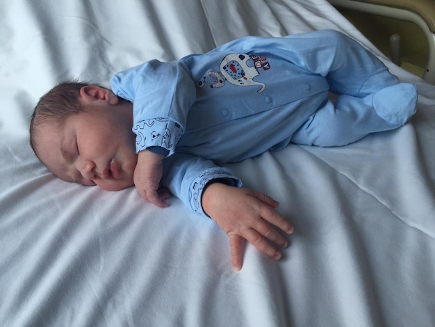 Foto vista de ángulo alto de un recién nacido tendido en la cama