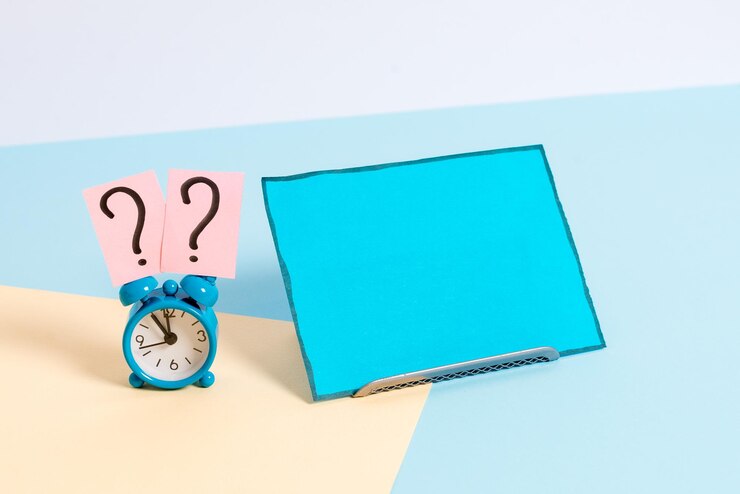 Foto vista de ángulo alto del reloj en la mesa contra un fondo blanco