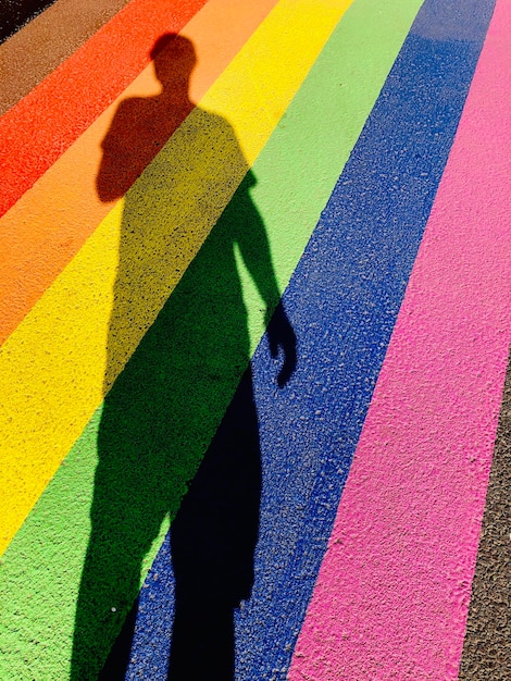 Foto vista de ángulo alto de la sombra de una persona en una calle multicolor