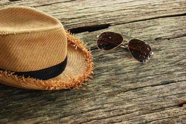 Vista de ángulo alto del sombrero con gafas de sol en una mesa de madera