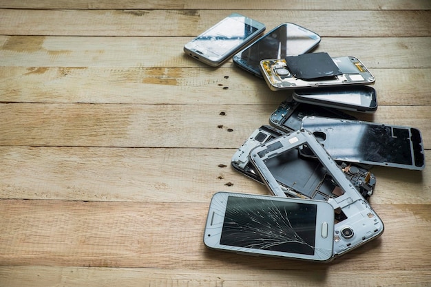 Vista de ángulo alto de un teléfono inteligente dañado en una mesa de madera