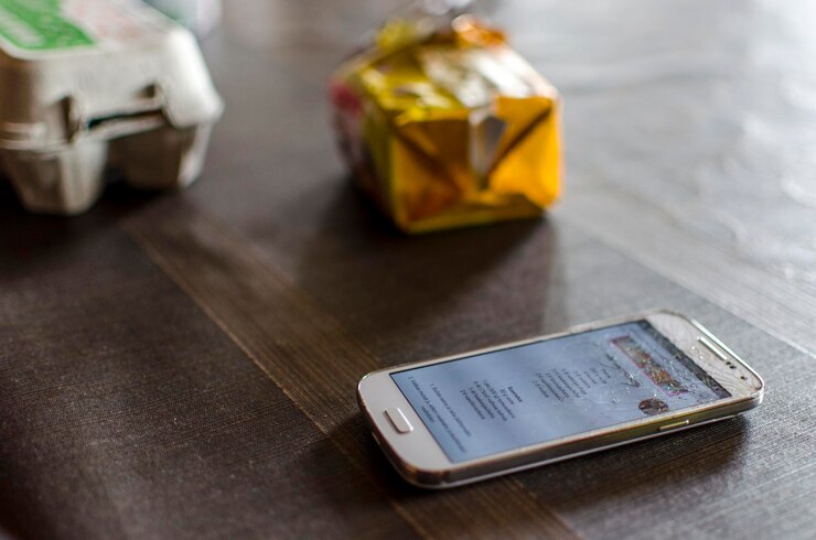 Foto vista de ángulo alto de un teléfono inteligente roto en la mesa