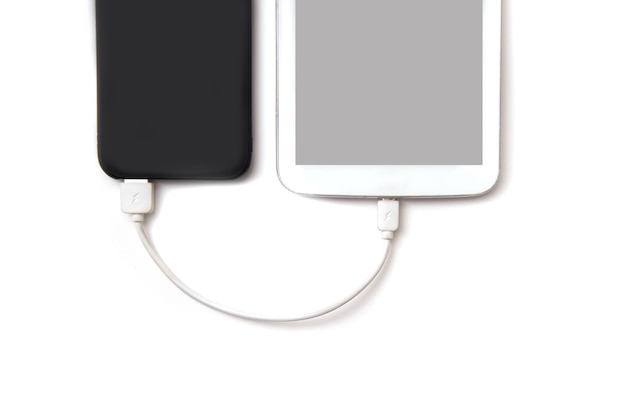 Foto vista de ángulo alto del teléfono móvil y la batería con cable usb sobre fondo blanco