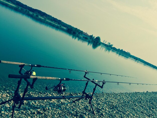 Vista de ángulo alto de las varas de pesca en la orilla del río