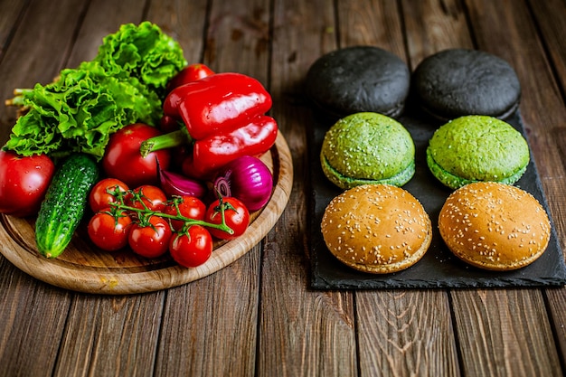 Vista de ángulo alto de la variedad de seis panes de hamburguesa con verduras en la mesa Negro verde amarillo