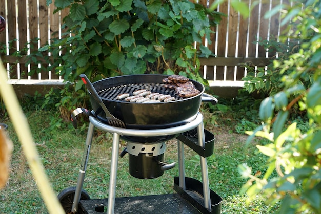 Vista de ángulo alto de varios alimentos en la parrilla de barbacoa en el patio