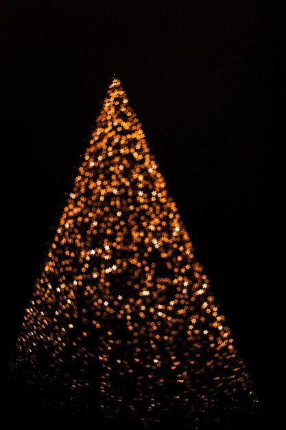 Foto vista de ángulo bajo del árbol de navidad iluminado contra el cielo por la noche