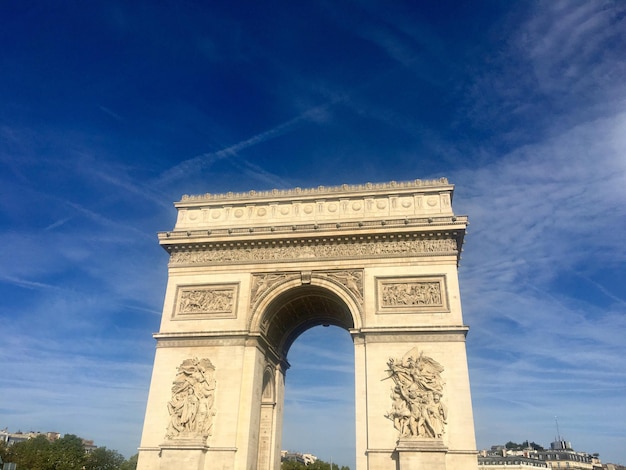 Vista en bajo ángulo del arco triunfal contra un cielo nublado