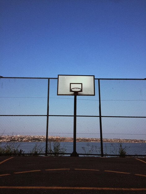 Foto vista de ángulo bajo del aro de baloncesto contra un cielo azul claro