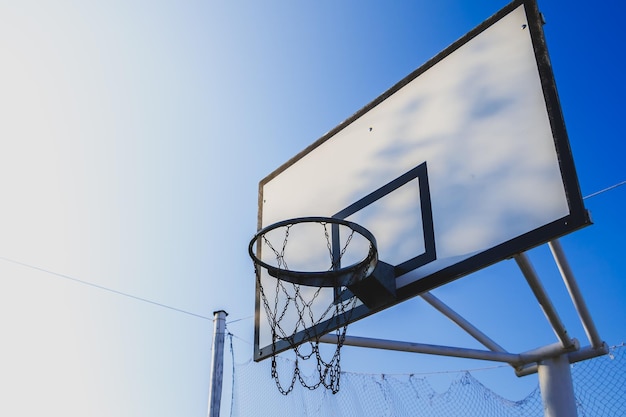 Vista de ángulo bajo del aro de baloncesto contra el cielo azul