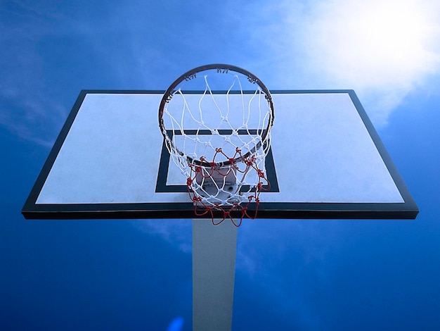 Vista de ángulo bajo del aro de baloncesto contra el cielo azul