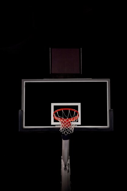 Foto vista de ángulo bajo del aro de baloncesto contra un fondo negro