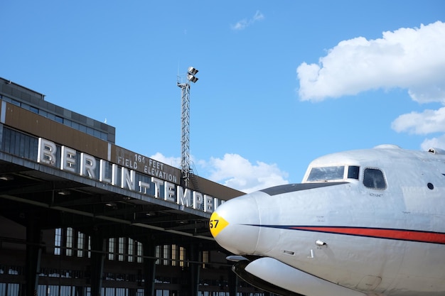 Foto vista de ángulo bajo del avión por el edificio del aeropuerto contra el cielo