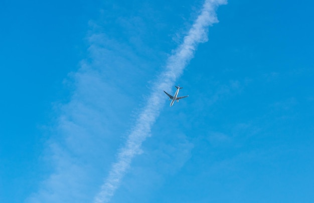 Vista de bajo ángulo de un avión volando contra el cielo azul