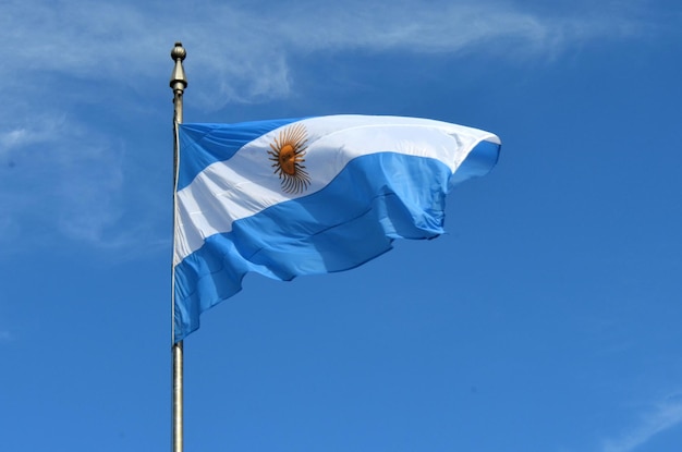Vista en bajo ángulo de la bandera argentina contra el cielo azul