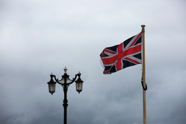 Vista de ángulo bajo de la bandera británica con lámpara de calle contra el cielo