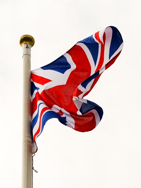 Vista de bajo ángulo de la bandera británica ondeando contra el cielo nublado