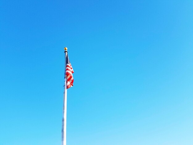 Foto vista en bajo ángulo de la bandera contra un cielo azul claro