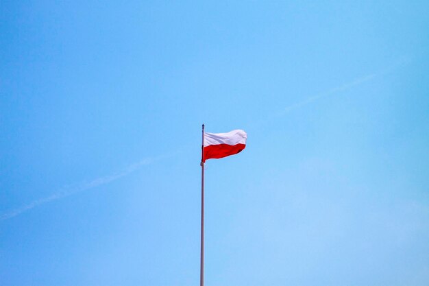 Vista en bajo ángulo de la bandera contra un cielo azul claro