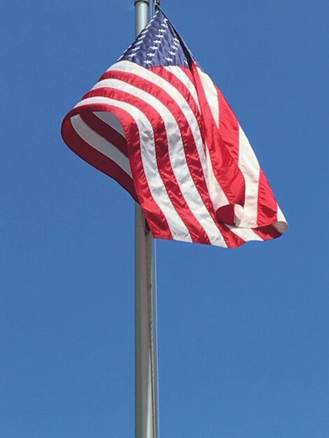 Vista en bajo ángulo de la bandera contra un cielo azul claro