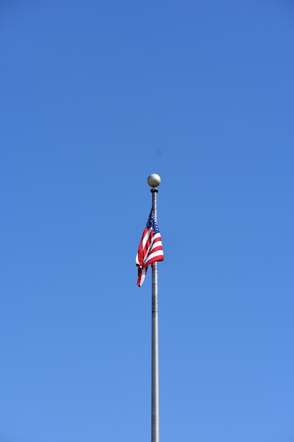 Foto vista en bajo ángulo de la bandera contra un cielo azul claro