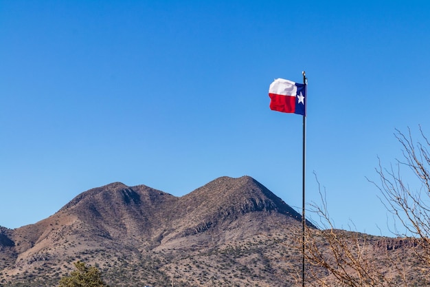 Foto vista de ángulo bajo de la bandera contra la cordillera contra el cielo azul