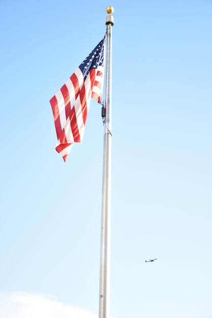 Vista de ángulo bajo de la bandera estadounidense contra el cielo azul