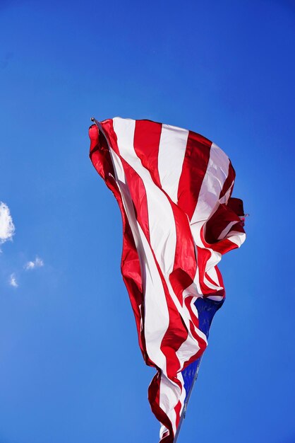 Foto vista en bajo ángulo de la bandera roja contra el cielo azul