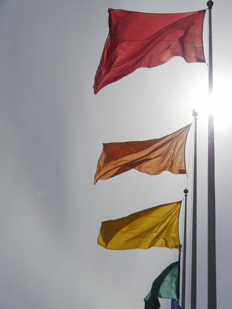 Foto vista de ángulo bajo de banderas coloridas contra el cielo en un día soleado