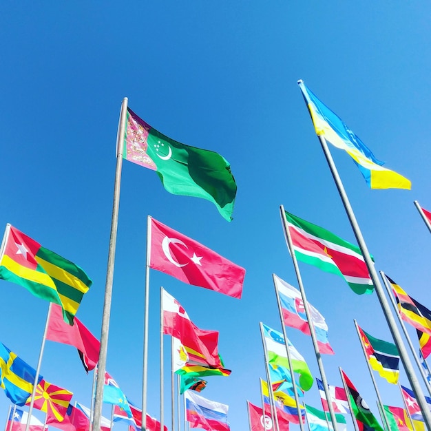 Vista de ángulo bajo de las banderas globales contra el cielo