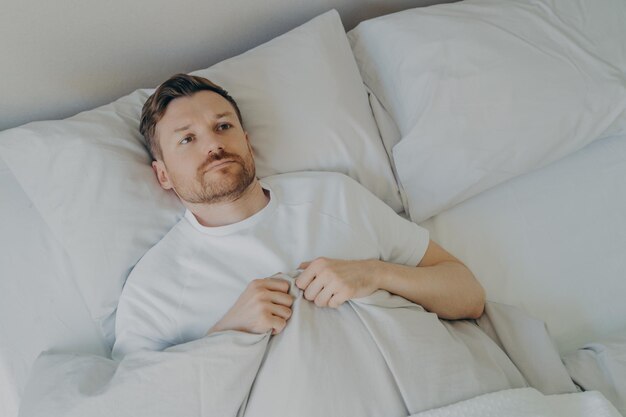 Foto vista de bajo ángulo del bebé durmiendo en la cama en casa