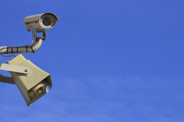 Vista de ángulo bajo de la cámara de seguridad contra el cielo azul